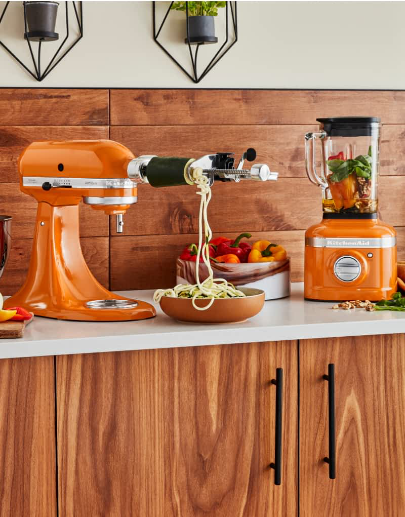 A KitchenAid® Stand Mixer with a Spiralizer Attachment, and a Blender in Honey.