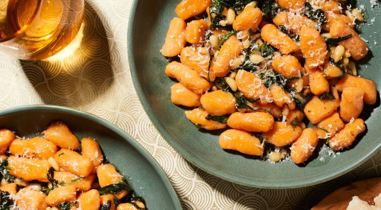 Two large, dark plates filled with sweet potato gnocchi.