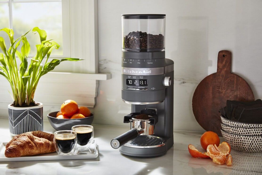 一个KitchenAid®Burr咖啡研磨机放在明亮的柜台上。＂loading=