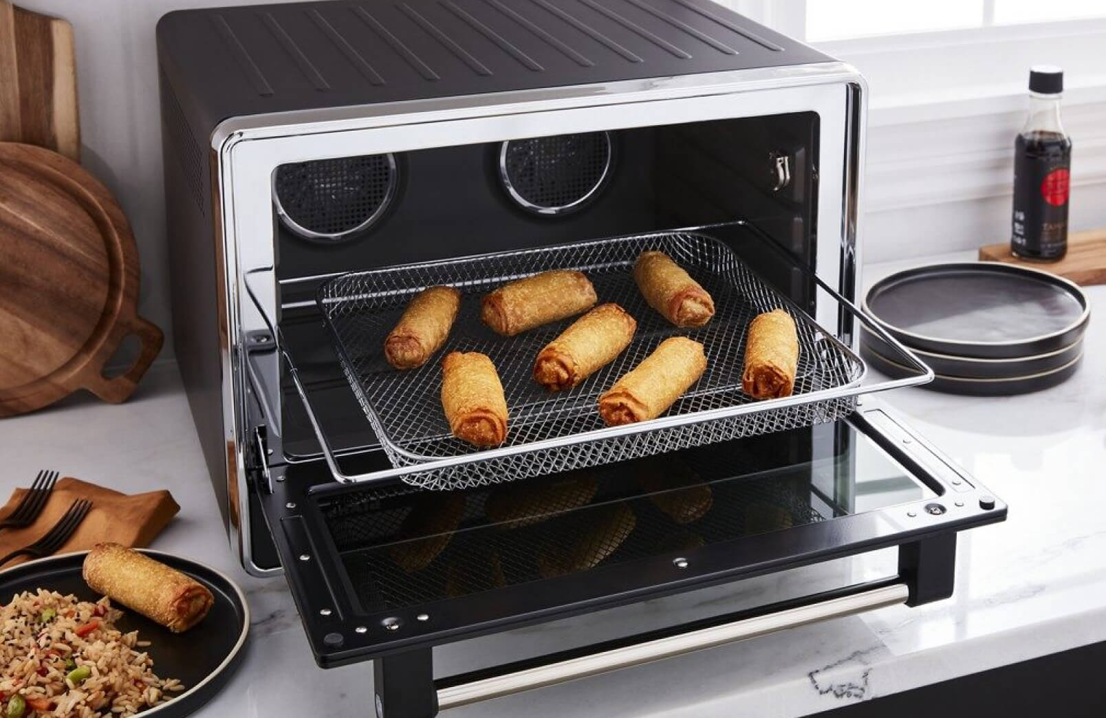 A KitchenAid® Dual Convection Countertop Oven with Air Fry frying egg rolls.
