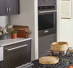 A KitchenAid® dishwasher and wall oven along a wall, with a gas cooktop on an island.