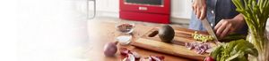 Woman cooking with red kitchen range behind her.