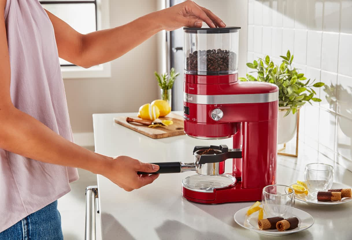Someone grinding coffee grounds with a KitchenAid® Burr Coffee Grinder