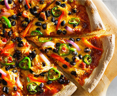 A sliced, freshly made pizza resting on a wooden cutting board.