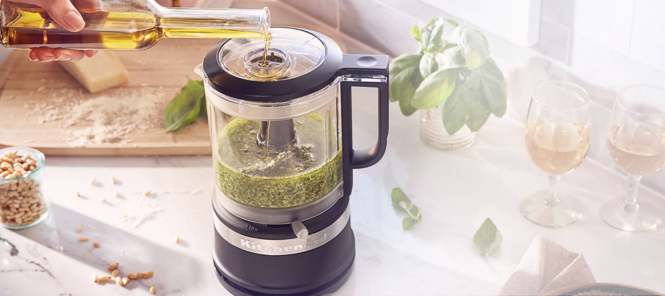 Un procesador de alimentos KitchenAid color negro picando verduras.