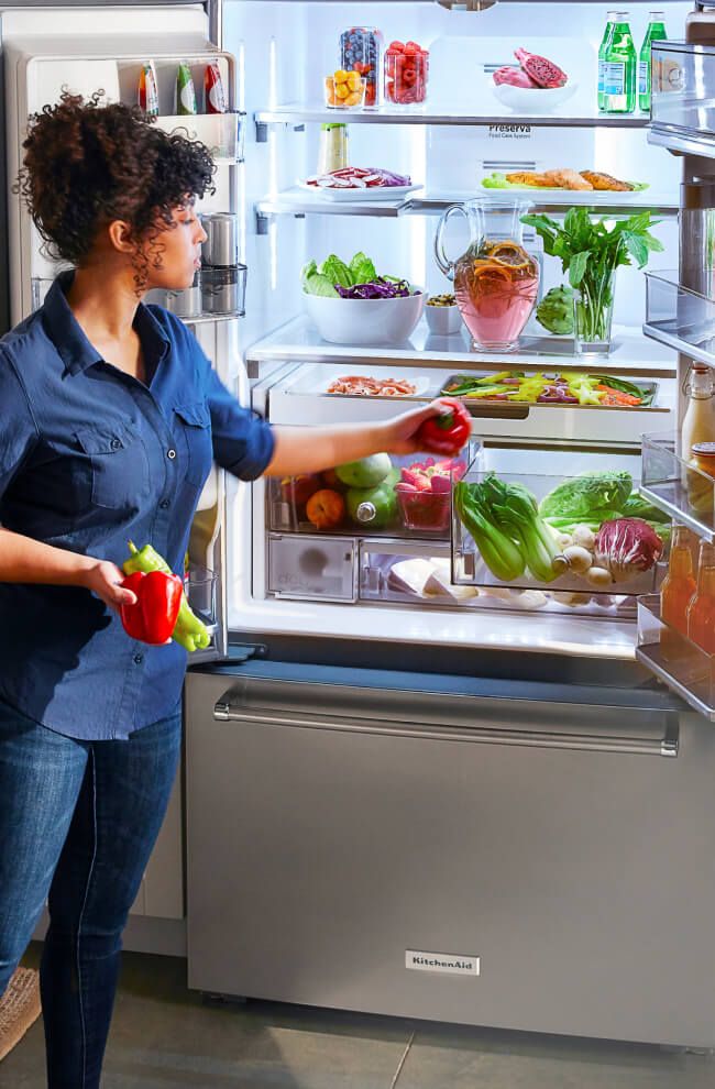 A person organizing their refrigerator.