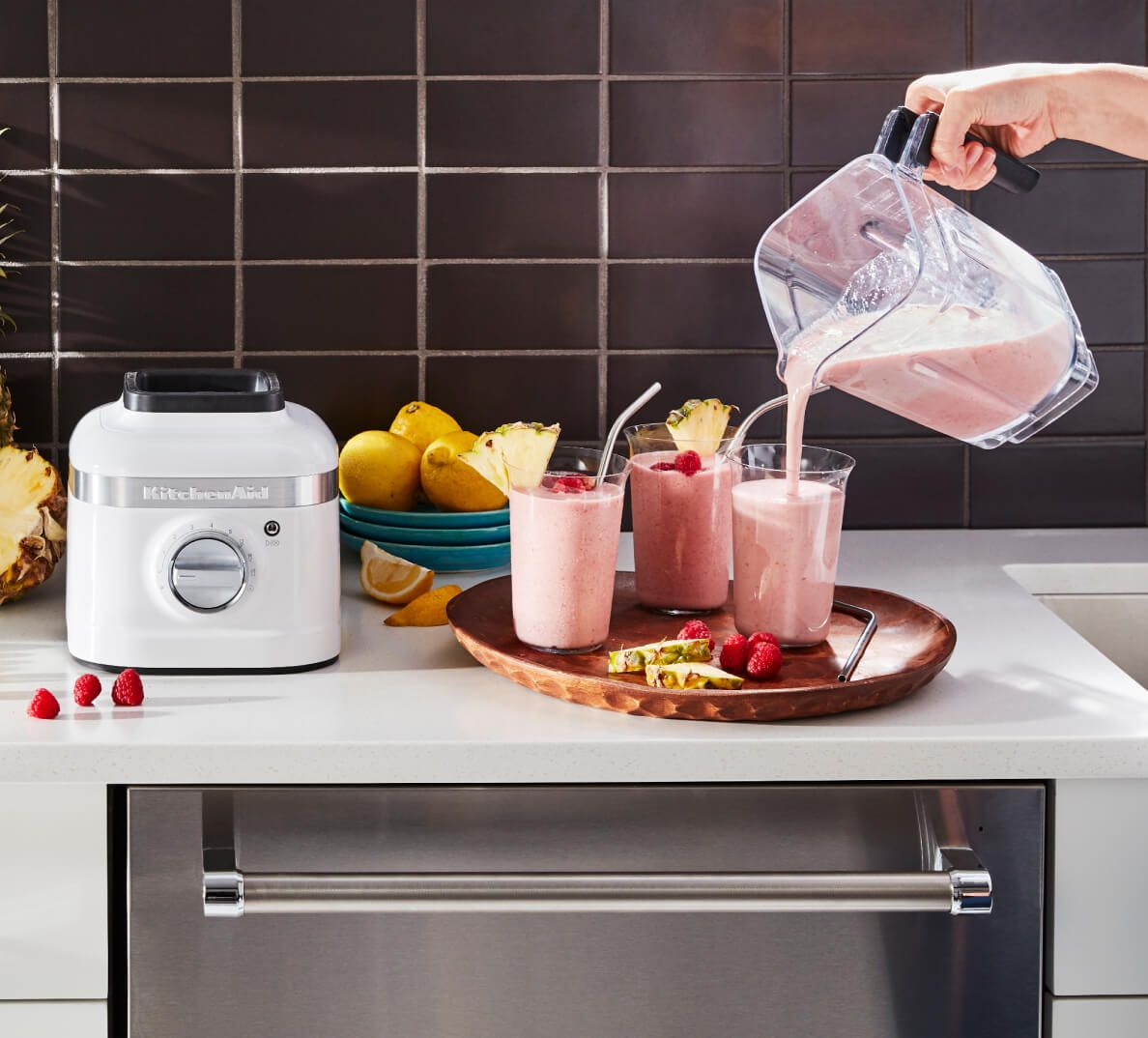 A smoothie being poured into three glasses.