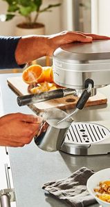 A person using the Automatic Milk Frother Attachment.
