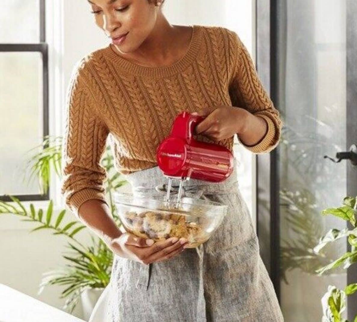 A person mixing batter with a KitchenAid® Hand Mixer.