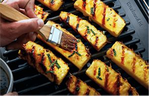 Una persona preparando un platillo en una parrilla KitchenAid.