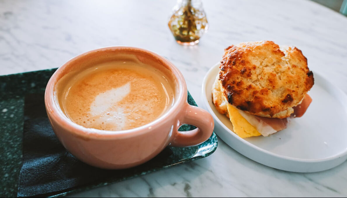A cappuccino and a freshly made breakfast sandwich.