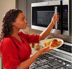 A person using a KitchenAid® Microwave.