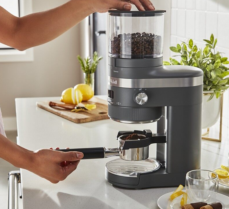 A person using a KitchenAid® Burr Grinder to make fresh espresso grounds.