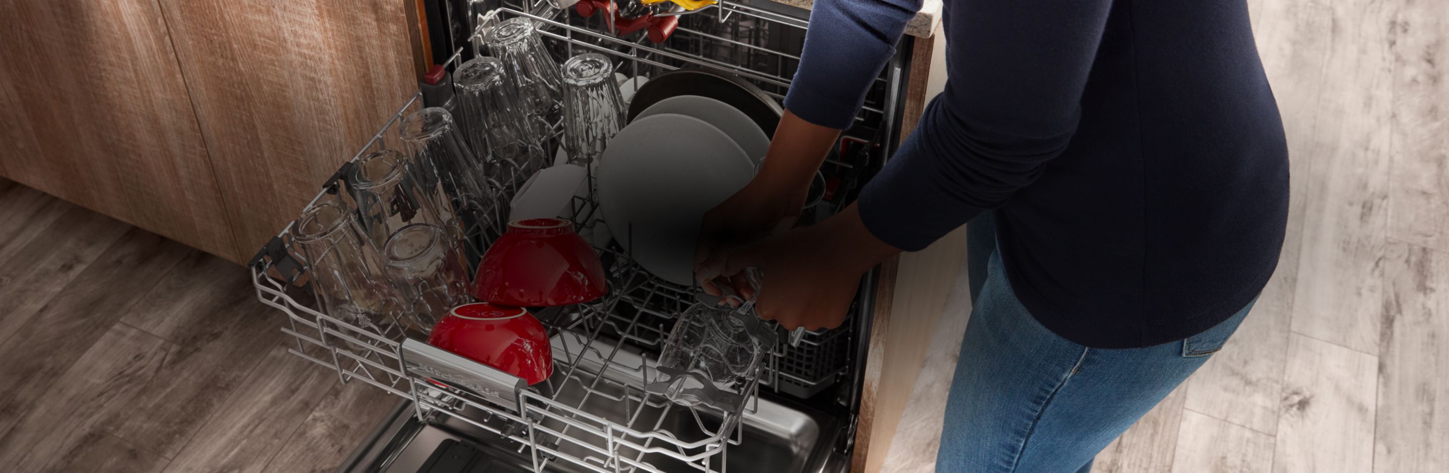 Loading a KitchenAid® dishwasher.