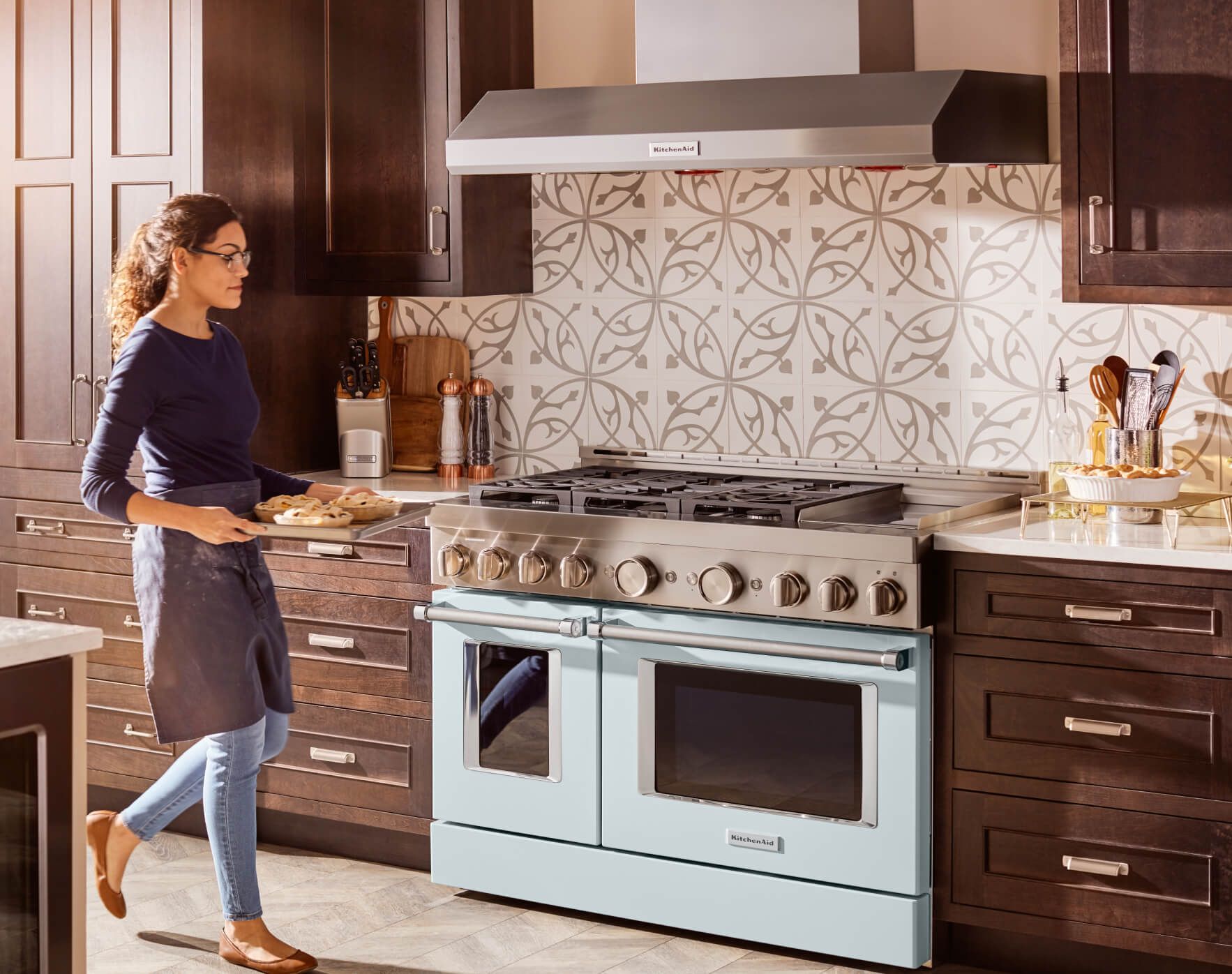 A Commerical-Style Range in a fully stocked kitchen with a young woman prepping pastries.