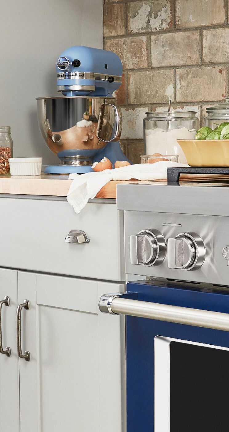 A kitchen featuring an Ink Blue Commercial-Style Range and a Tilt-Head Stand Mixer.