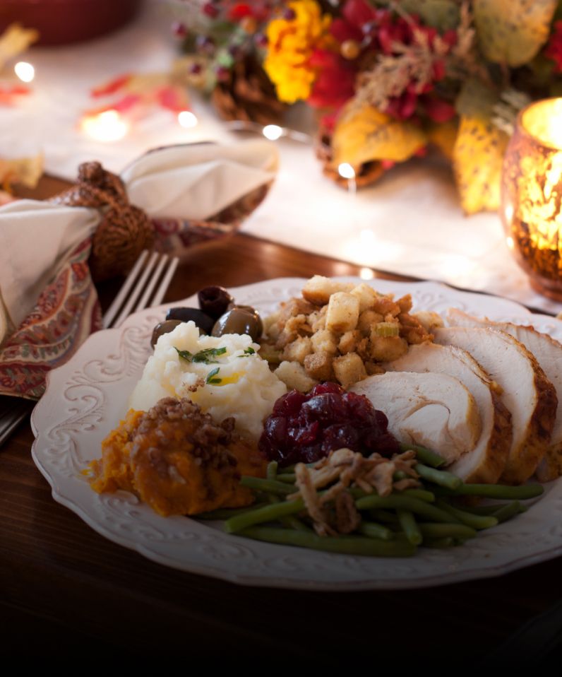 A dish full of different holidays foods, like turkey, stuffing and mashed potatoes. 