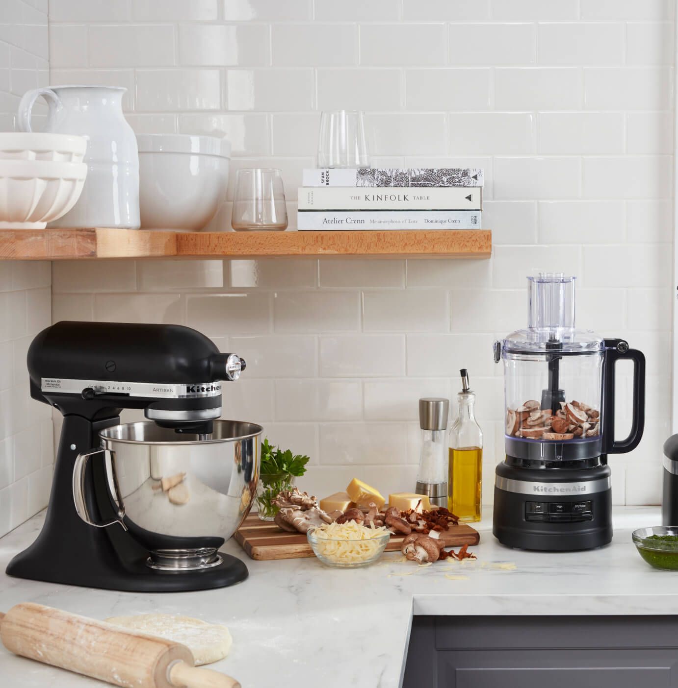 A KitchenAid® Stand Mixer and Food Processor in a crisp, stylish kitchen preparing fresh ingredients.