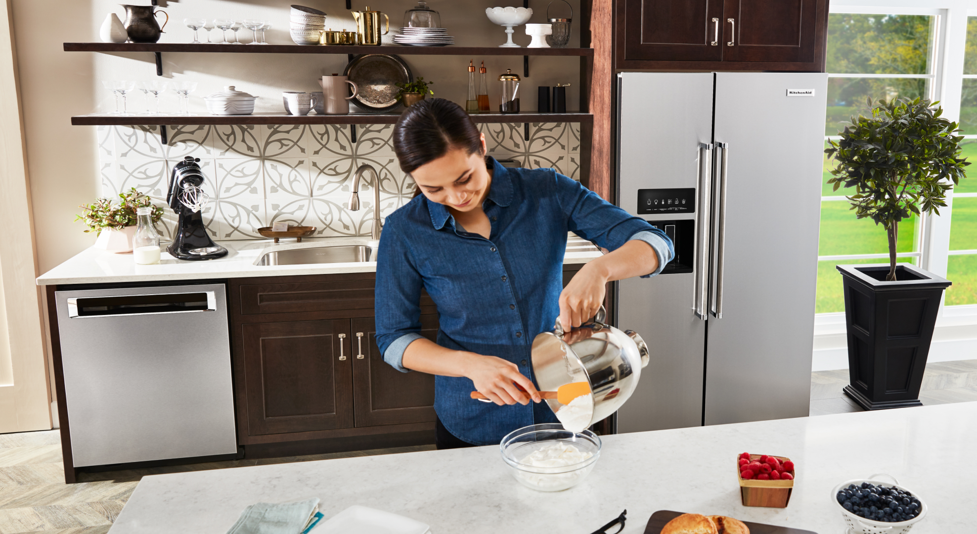 A person spiralizing zucchini with a KitchenAid® stand mixer.
