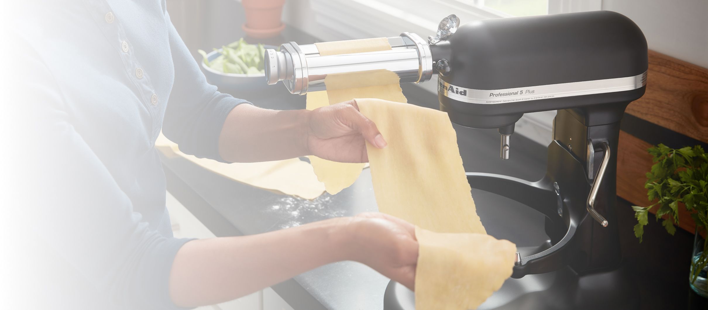 Rolling out pasta with a KitchenAid® Stand Mixer attachment.