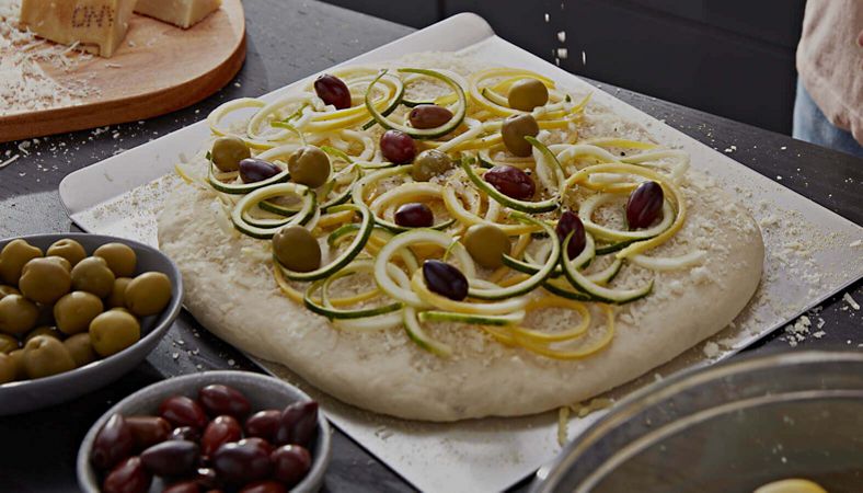 Olives and veggies on flatbread dough