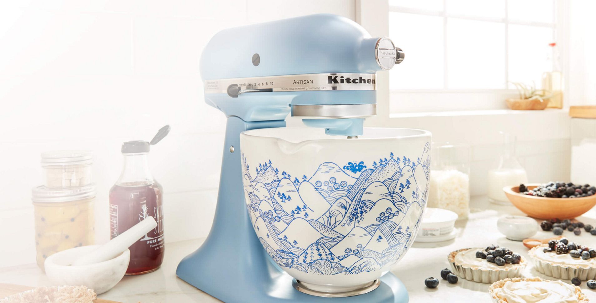 Light blue tilt-head Stand Mixer with white and blue flower-patterned ceramic bowl.