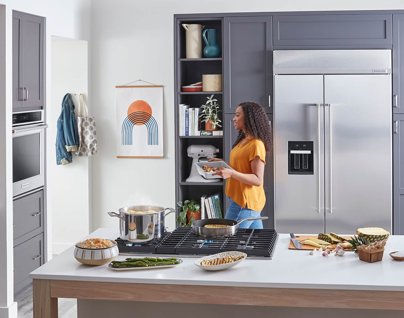 A modern kitchen with a maker preparing a meal, filled with KitchenAid® appliances. 
