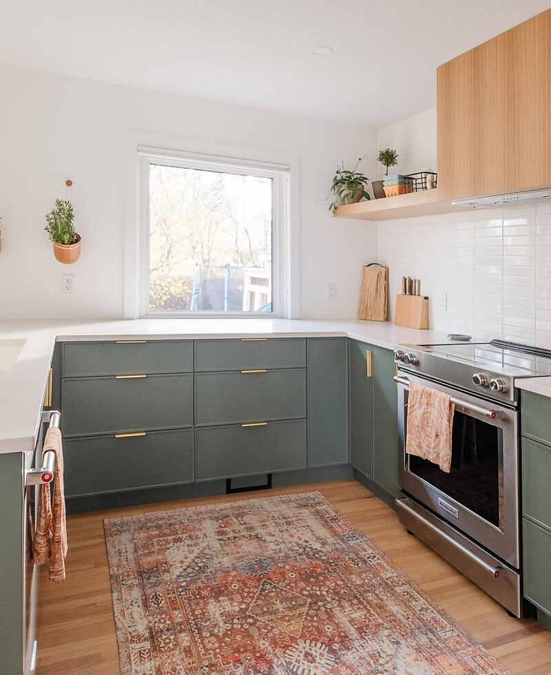 A kitchen with olive green cabinets, featuring a KitchenAid® range and dishwasher.