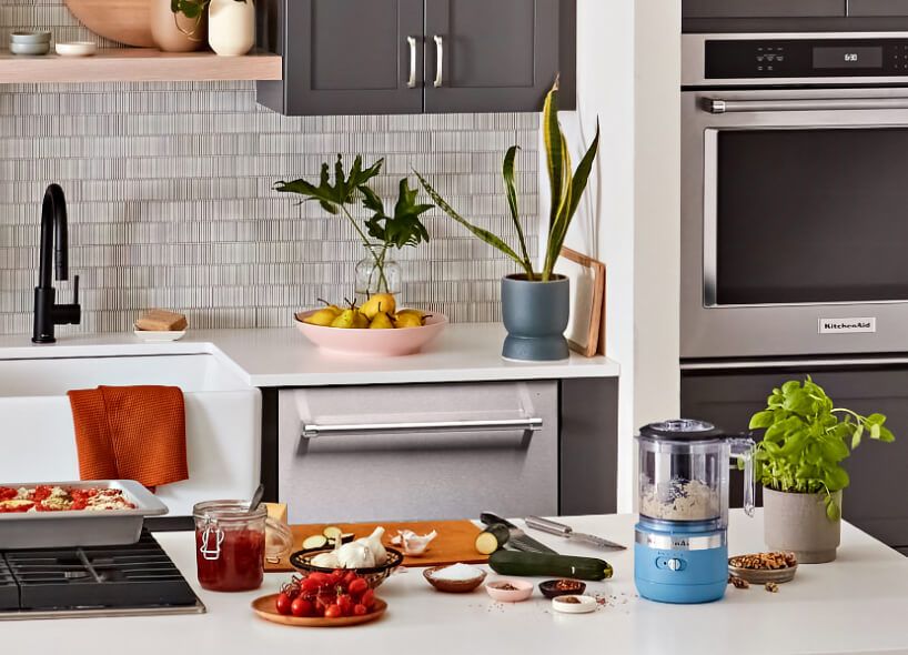 A kitchen featuring a KitchenAid® wall oven, dishwasher and countertop mini food processor.