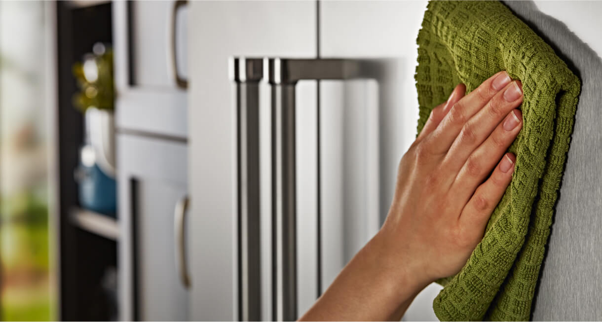 Cleaning exterior of a KitchenAid® Built-In Side-by-Side Refrigerator with microfiber cloth
