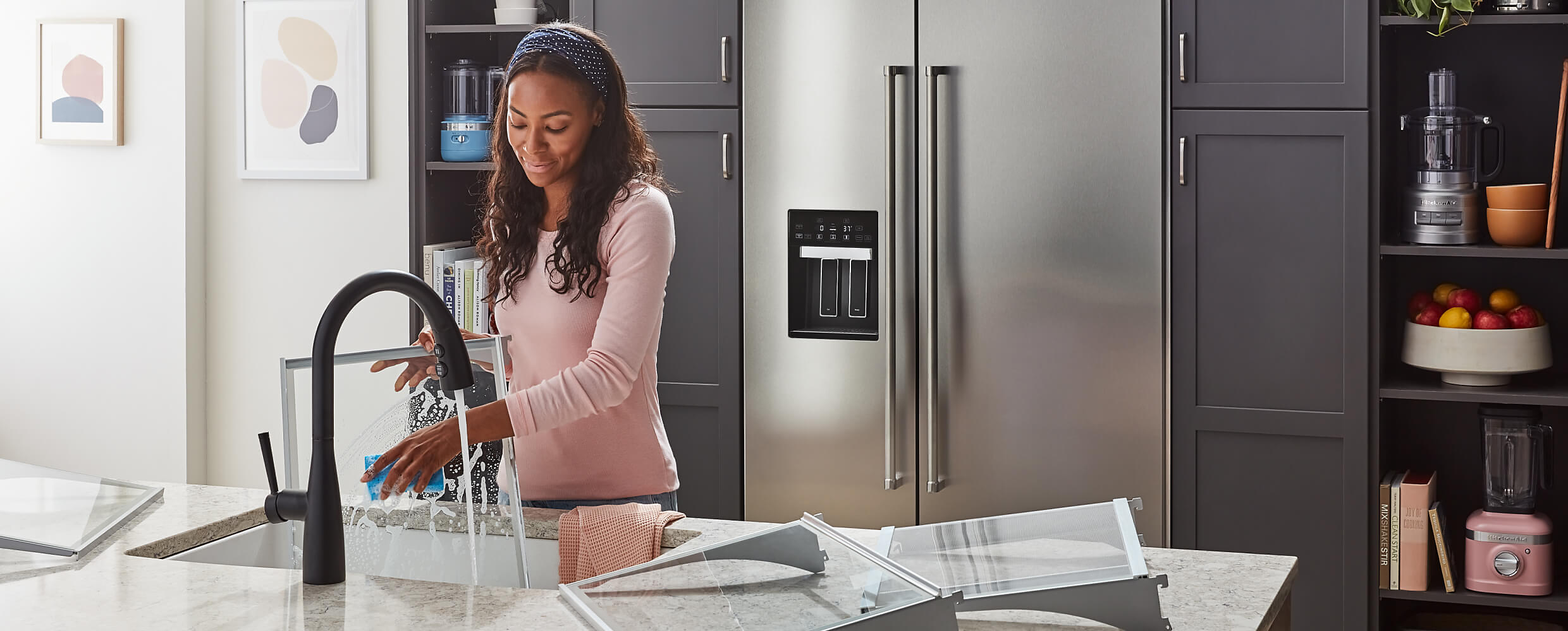 36" KitchenAid® Built-In Side-by-Side Refrigerator featured in the kitchen with a maker rinsing the bins and shelves