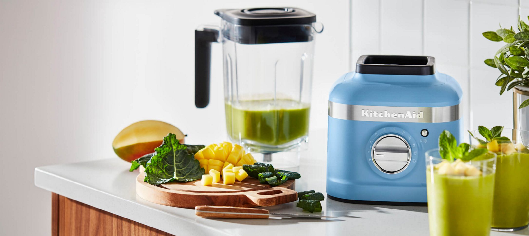 A Blue Velvet K400 Blender holding a green smoothie.