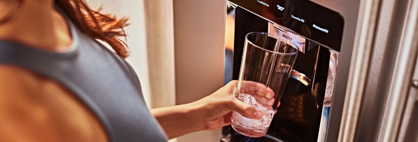 Filling a glass from a KitchenAid refrigerator water dispenser.