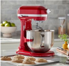 A red KitchenAid® Stand Mixer on a countertop with finished pastries. 