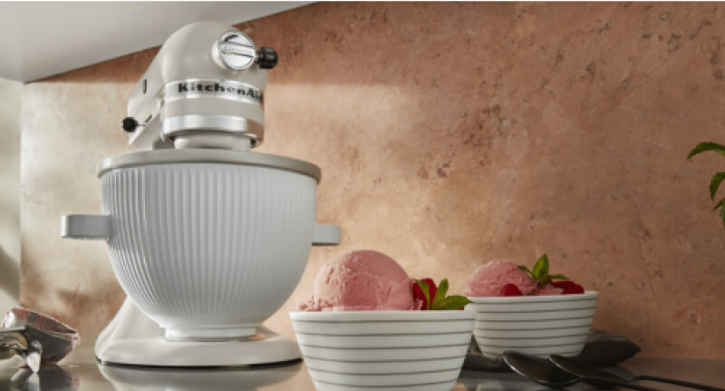 A KitchenAid® Stand Mixer using the ice cream maker attachment to make raspberry ice cream.
