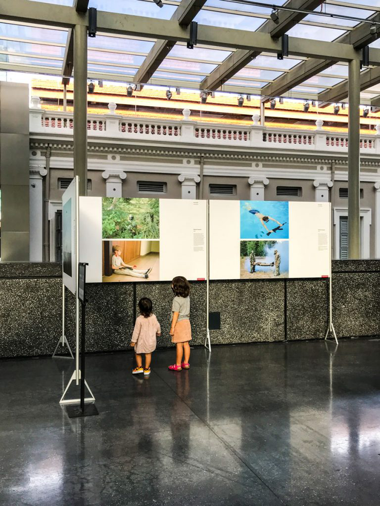 Two children looking at a photography exhibit in a museum.