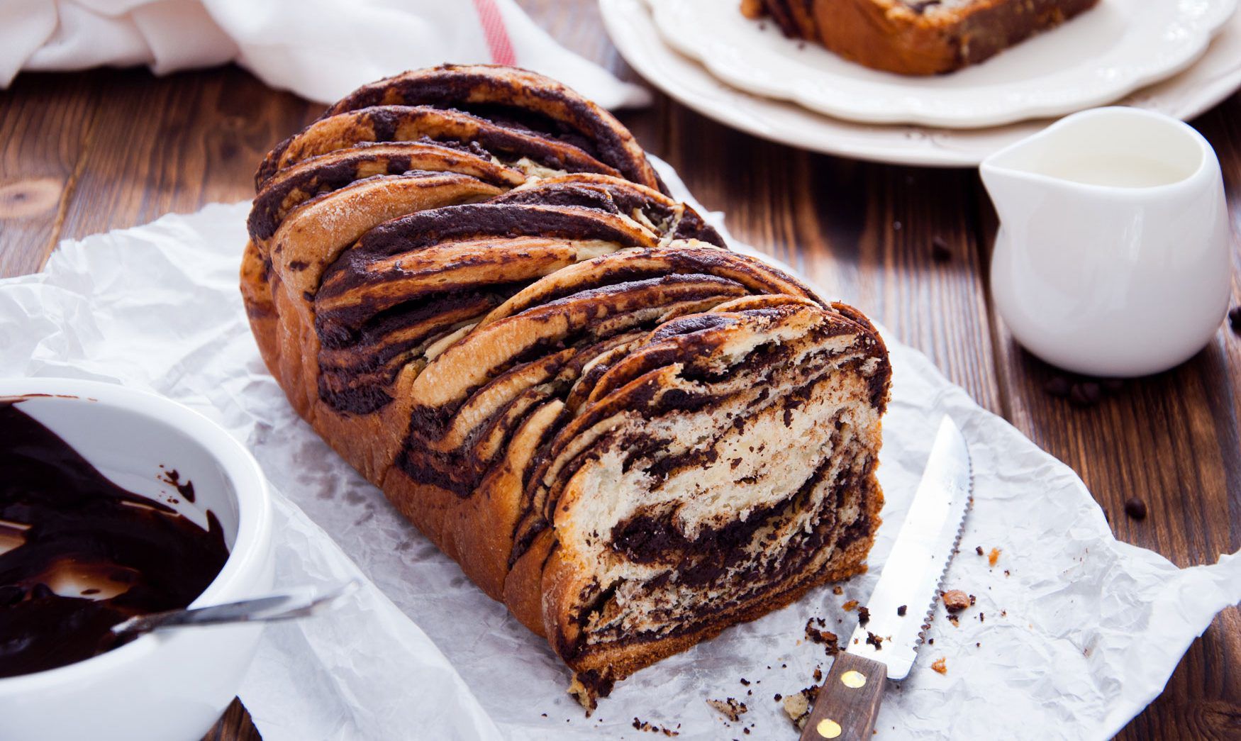Swirled babka bread resting on white parchment paper.