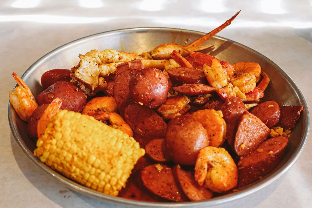 A metal bowl overflowing with a seafood boil.