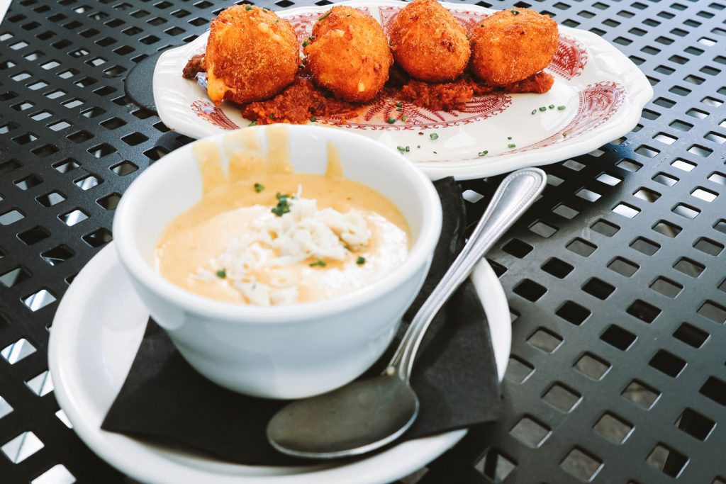 A dish of hushpuppies next to a small, delicate bowl.