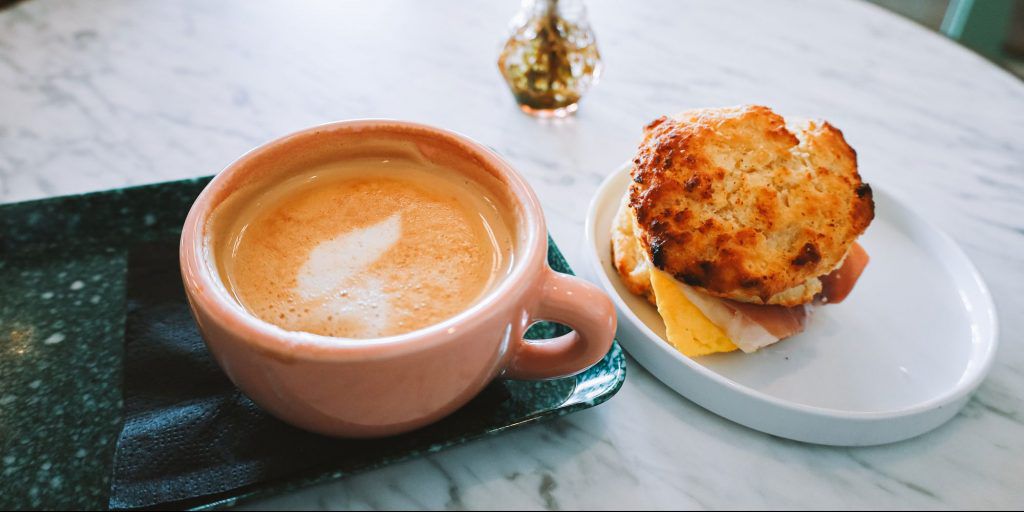 A cappuccino and a freshly made breakfast sandwich.