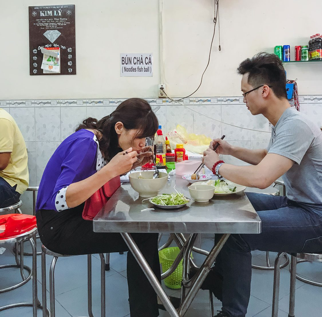 Two people enjoying their food at a small table.