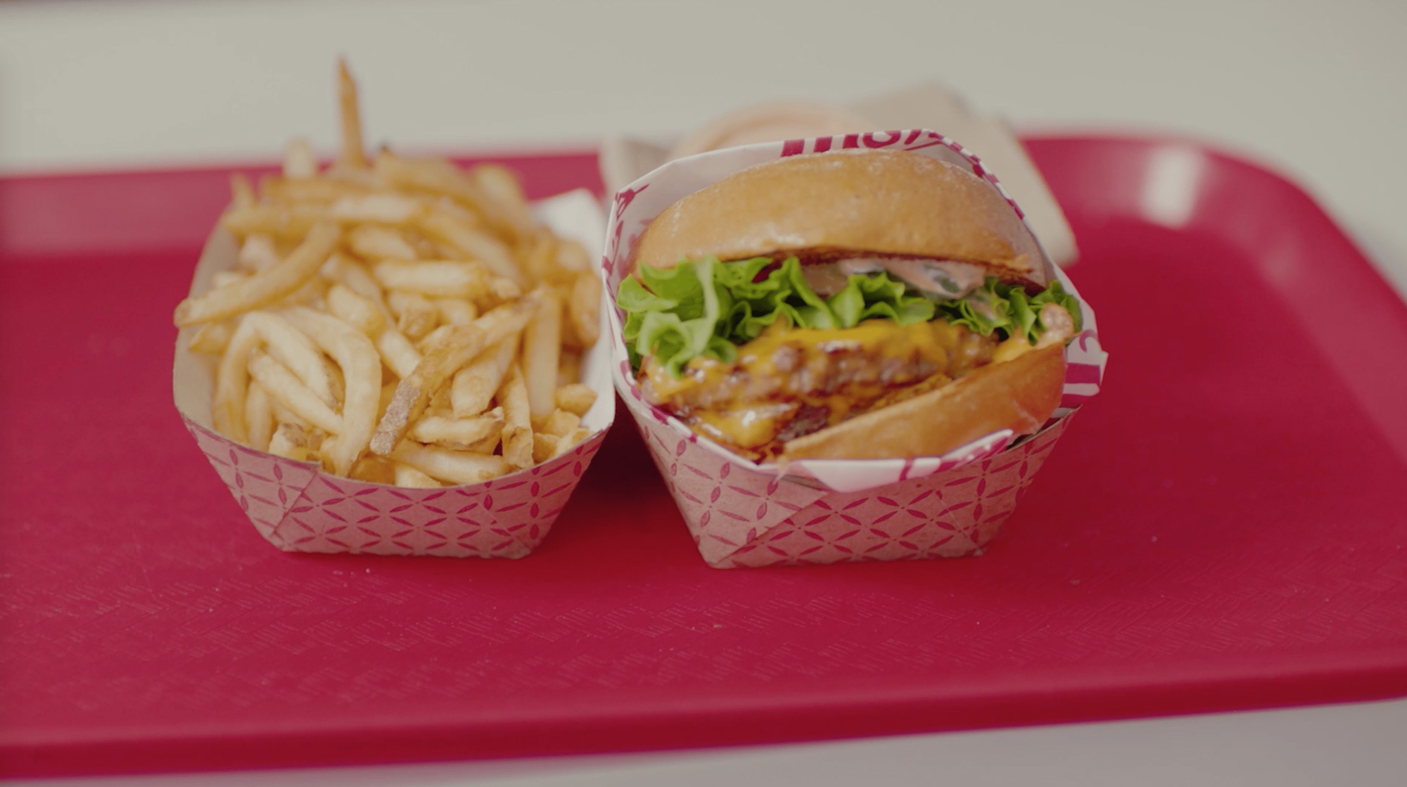 Two small paper baskets filled with french fries and a vegan burger.