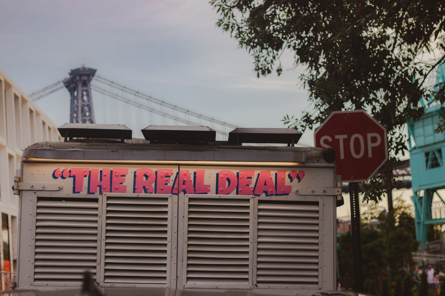 The back of an ice cream truck labeled with "The Real Deal" in bright pink.