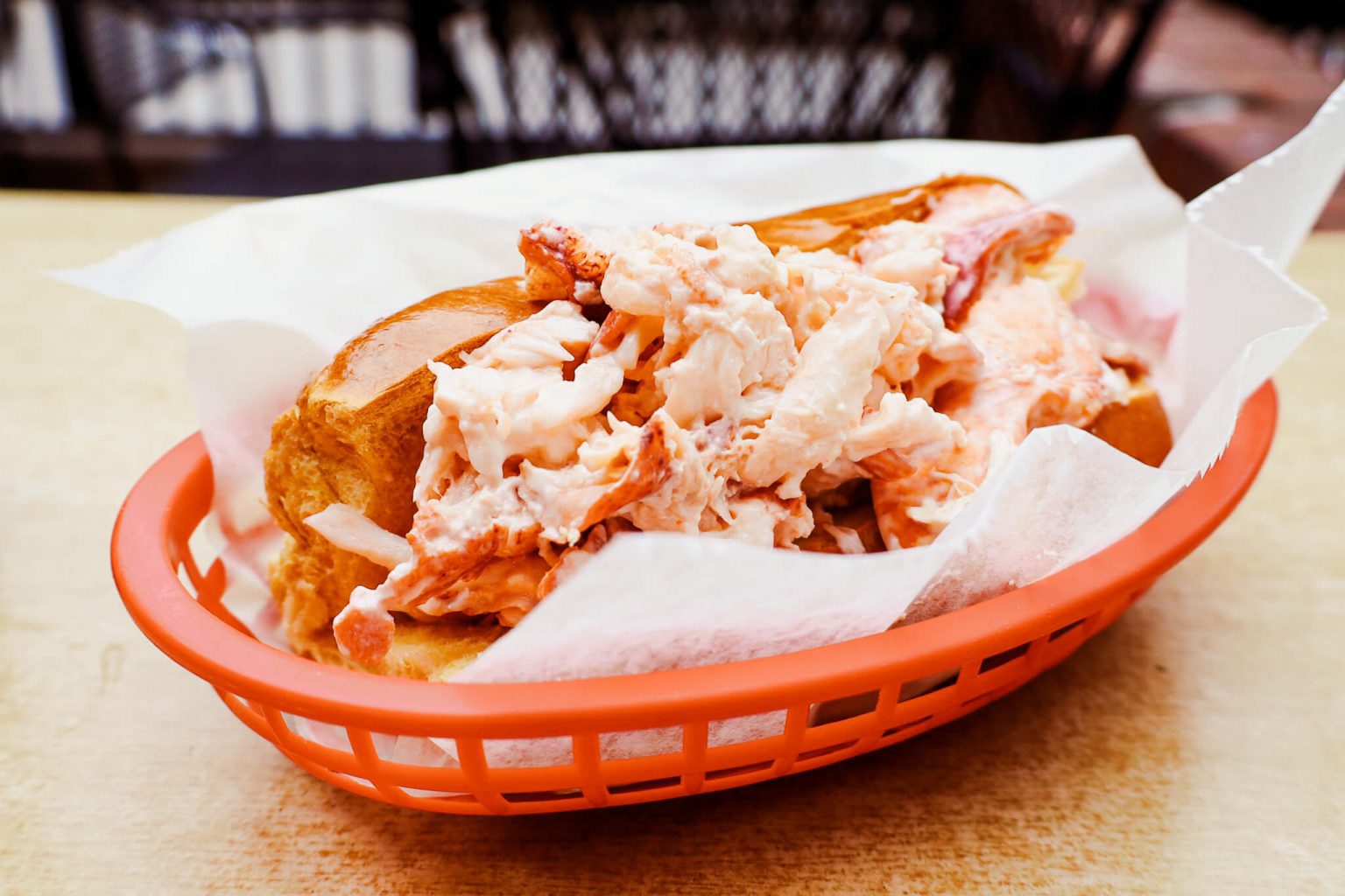 A lobster roll in a red basket.