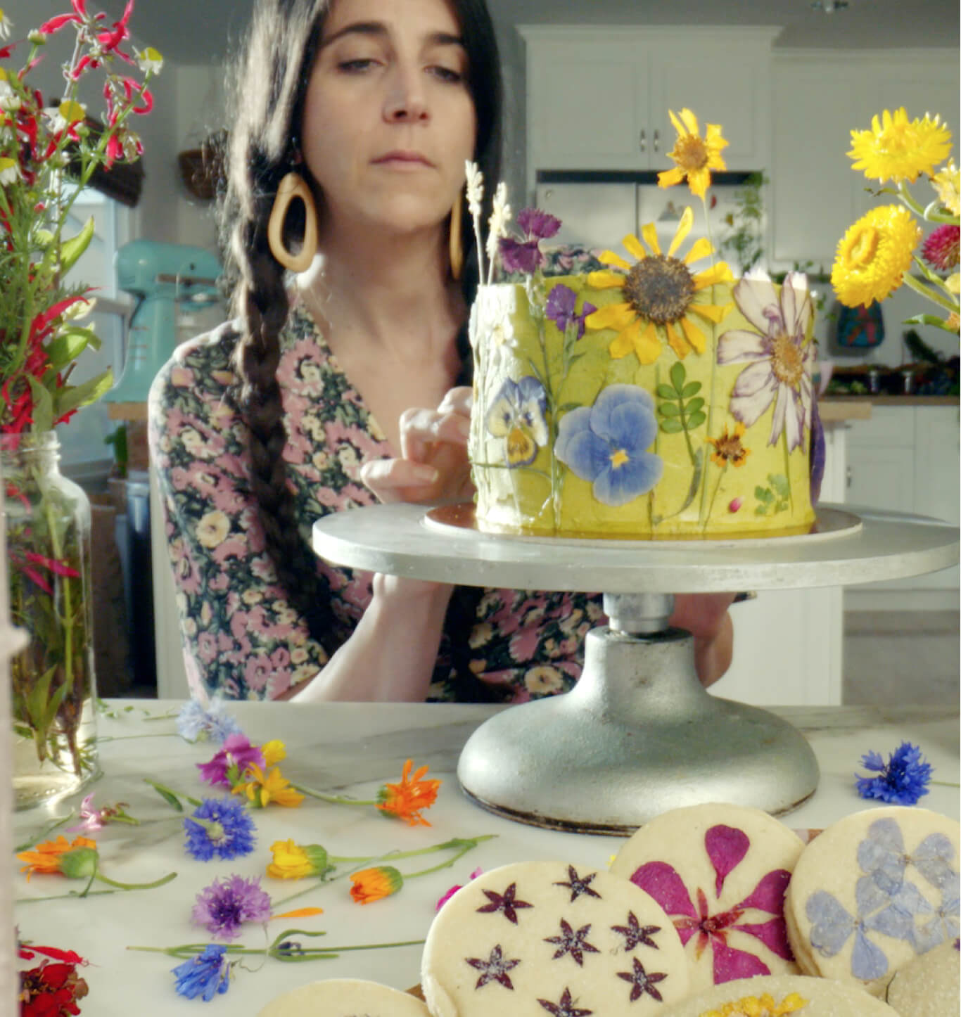 Loria Stern decorating a cake with edible flowers.