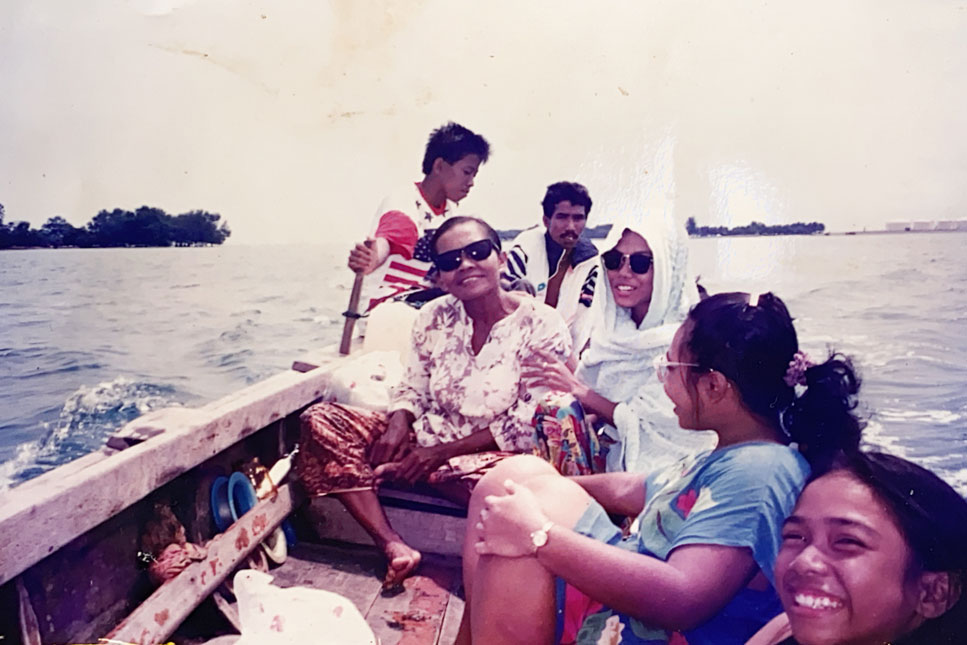 Firdaus Sani’s family posing for a picture on a boat.