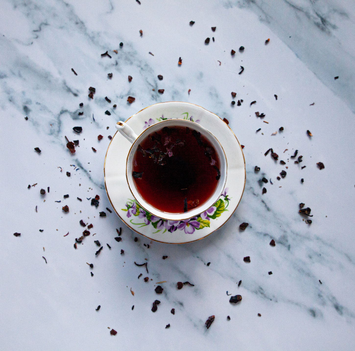 An elegant saucer and tea cup set filled with hot tea.