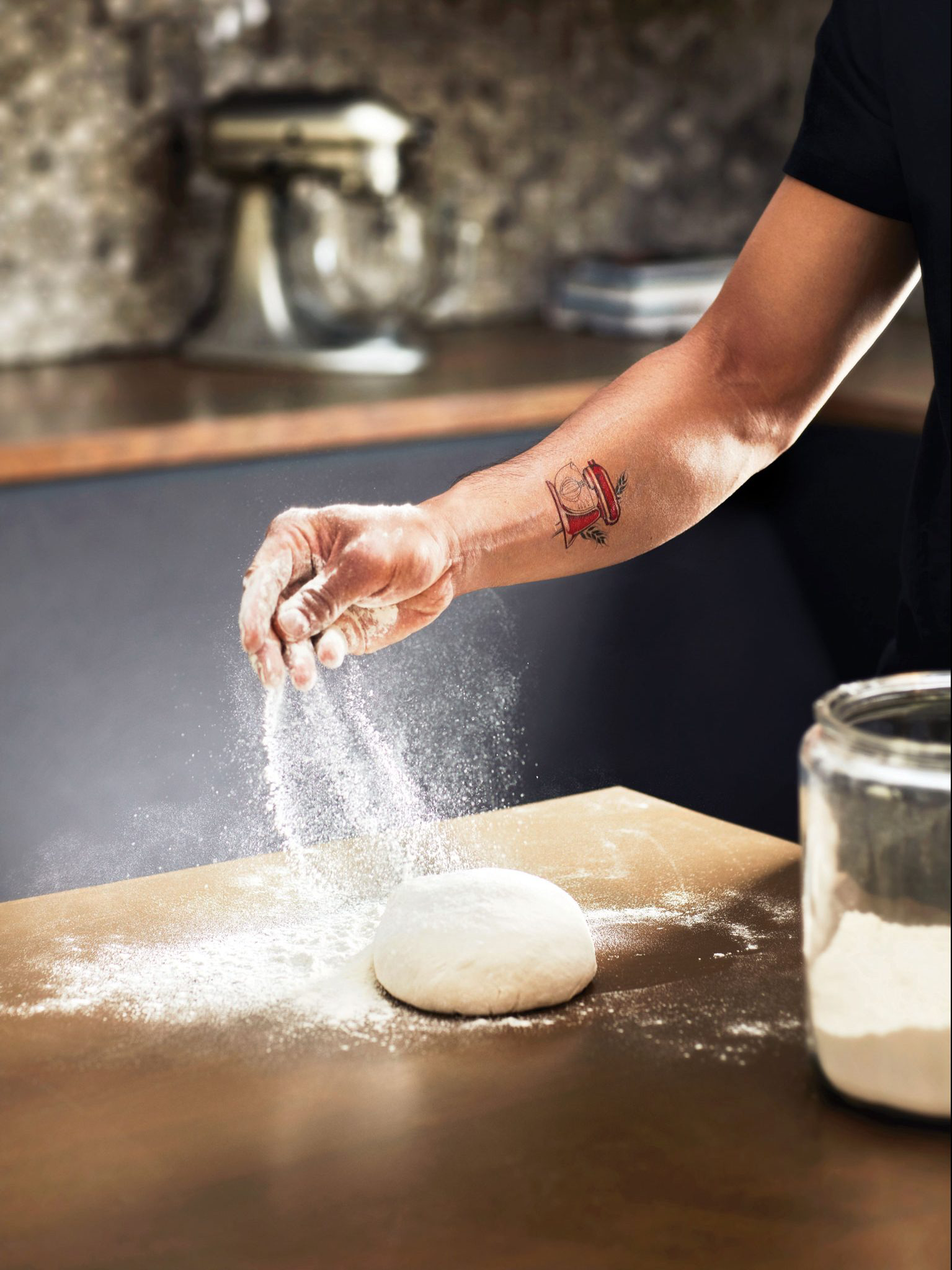 A person sprinkling flour on fresh dough.