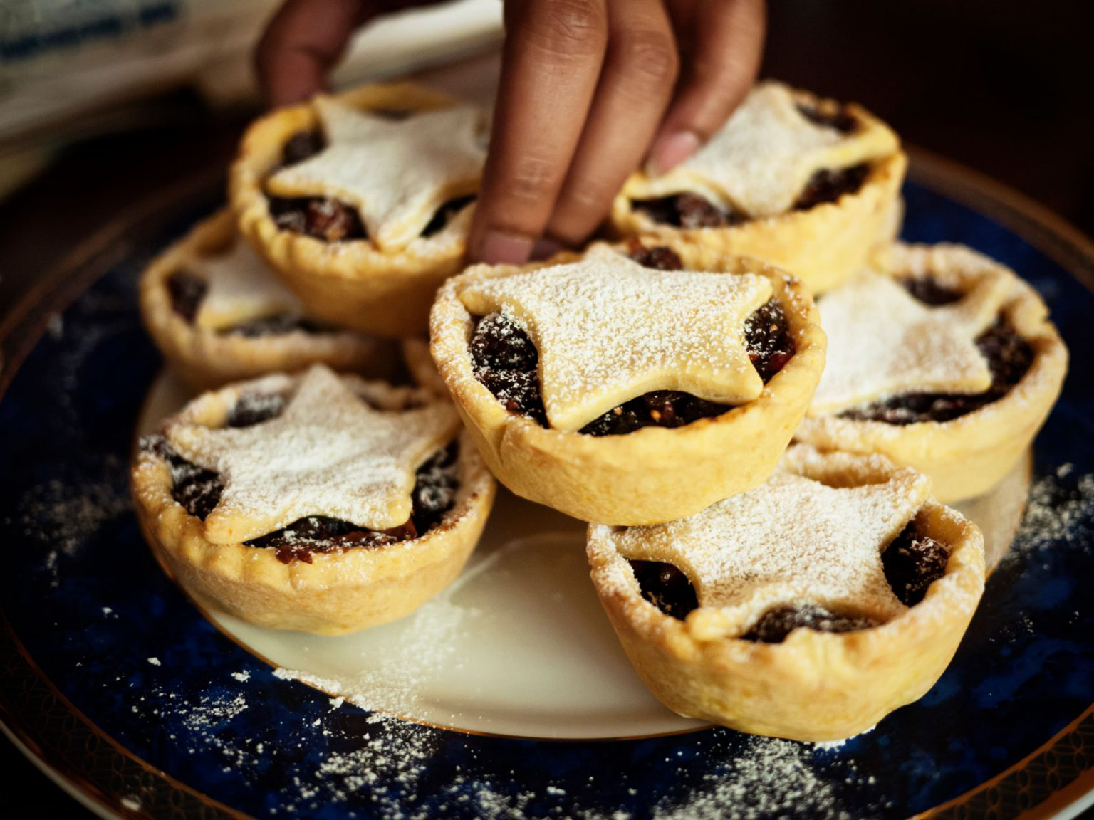 A dish filled with mini, starred mince pies.