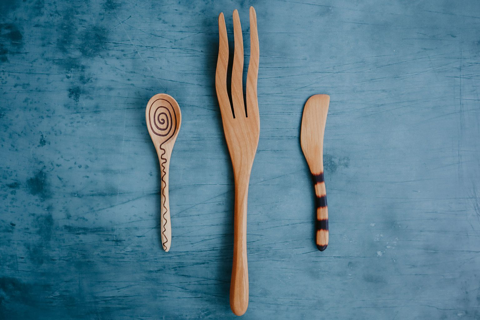 A uniquely designed wooden spoon, fork and knife.